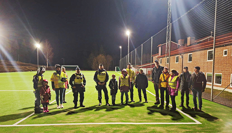 en grupp personer står tillsammans på en fotbollsplan.